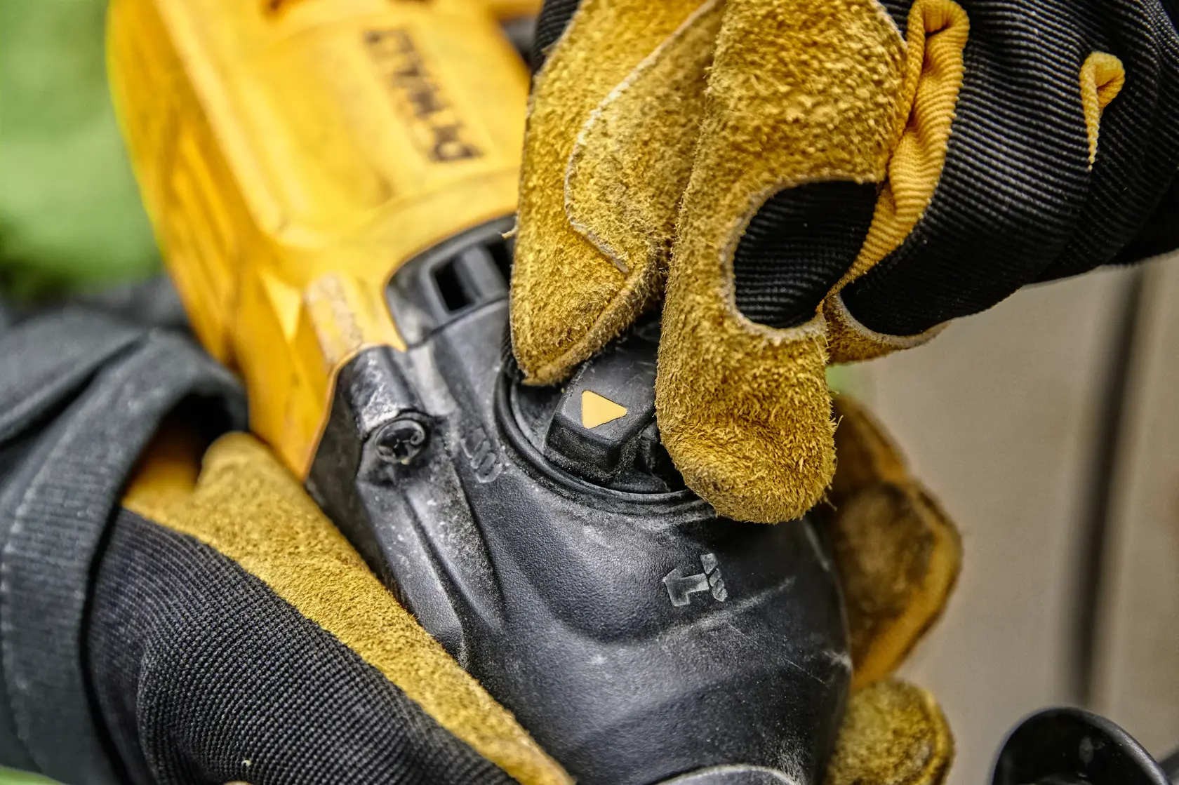 Vista de primer plano de una mano enguantada ajustando el selector de modo en una herramienta eléctrica DEWALT, mostrando el cuerpo amarillo y negro de la herramienta y el dial de control.