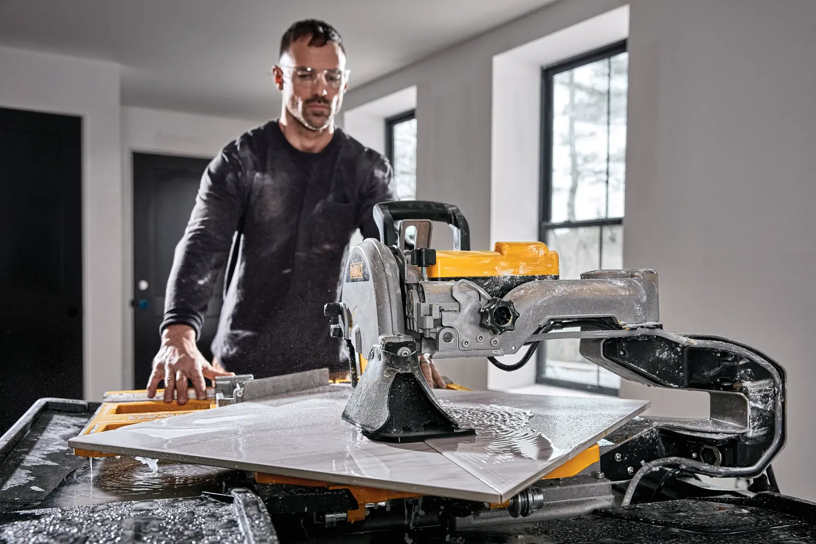 Foto del cortador de baldosas húmedo DEWALT en uso interior, SKU D36000-QS, D36000, agua y baldosa.
