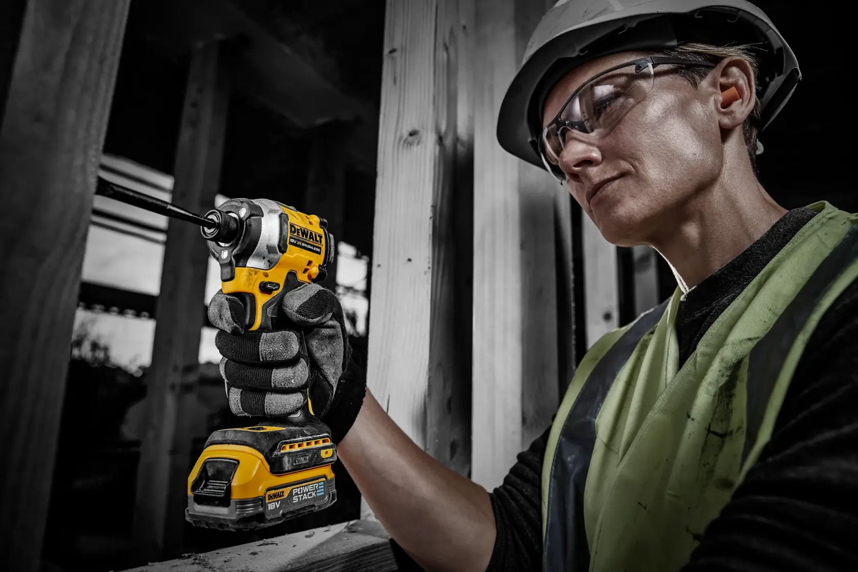 Trabajador usa herramienta DEWALT con batería DCBP034 en obra, rostro difuminado por privacidad.