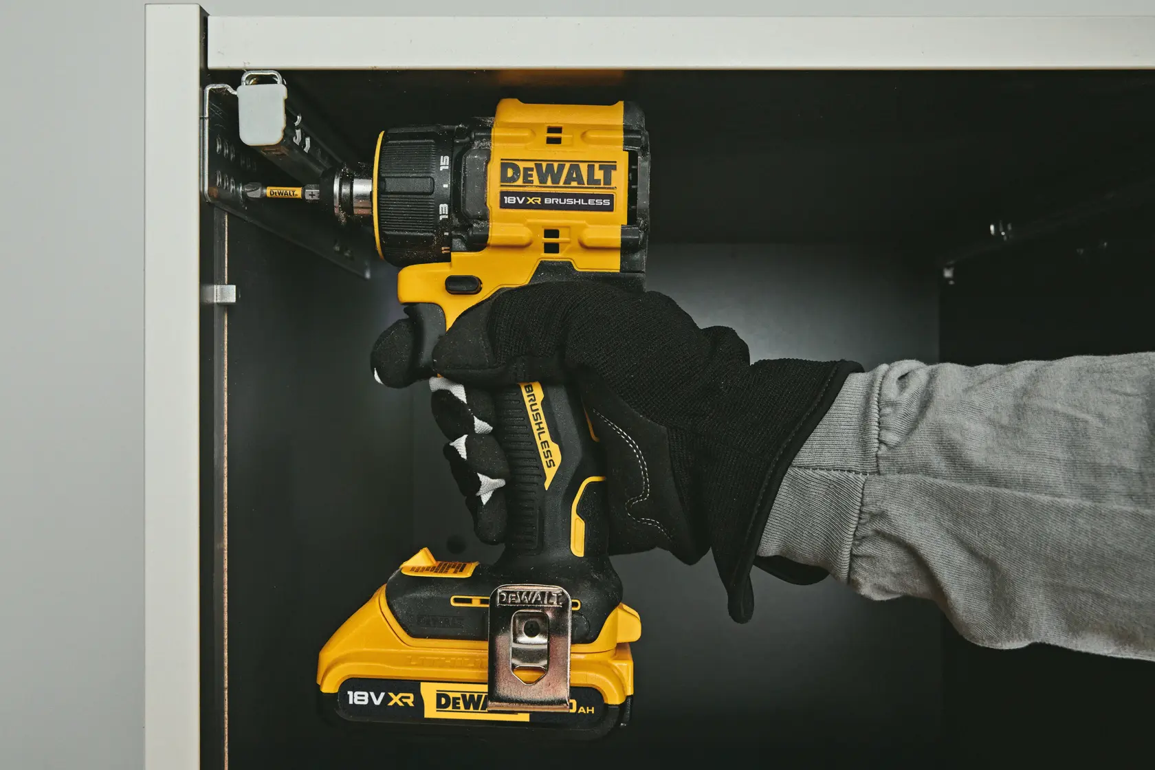 Taladro DEWALT DCD803NT-XJ, DCD803NT usándose en gabinete. Categoría fotografía. Mano con guante visible.
