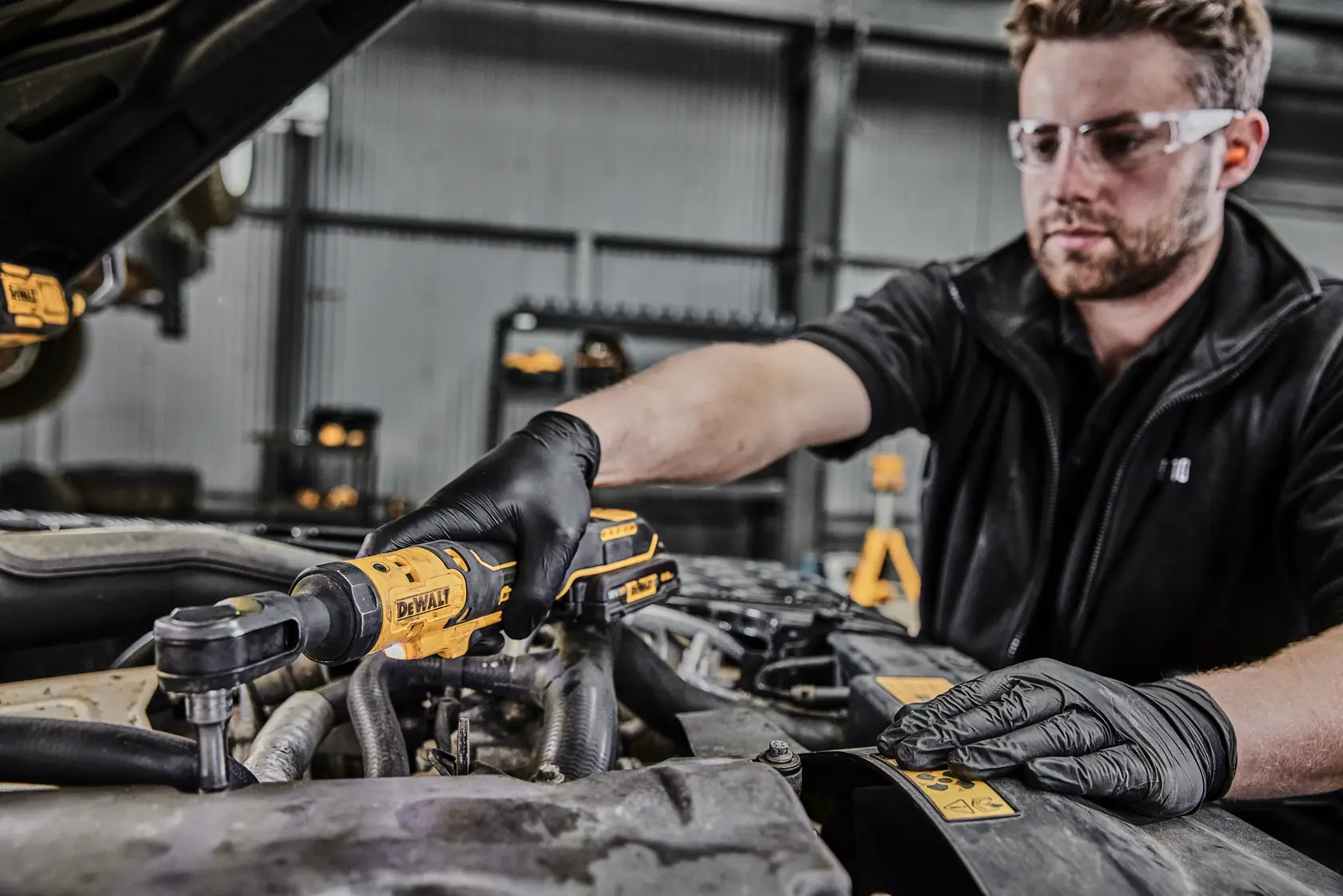 Foto de mecánico usando DEWALT DCF512N-XJ, DCF512N trinquete en motor de coche en taller.