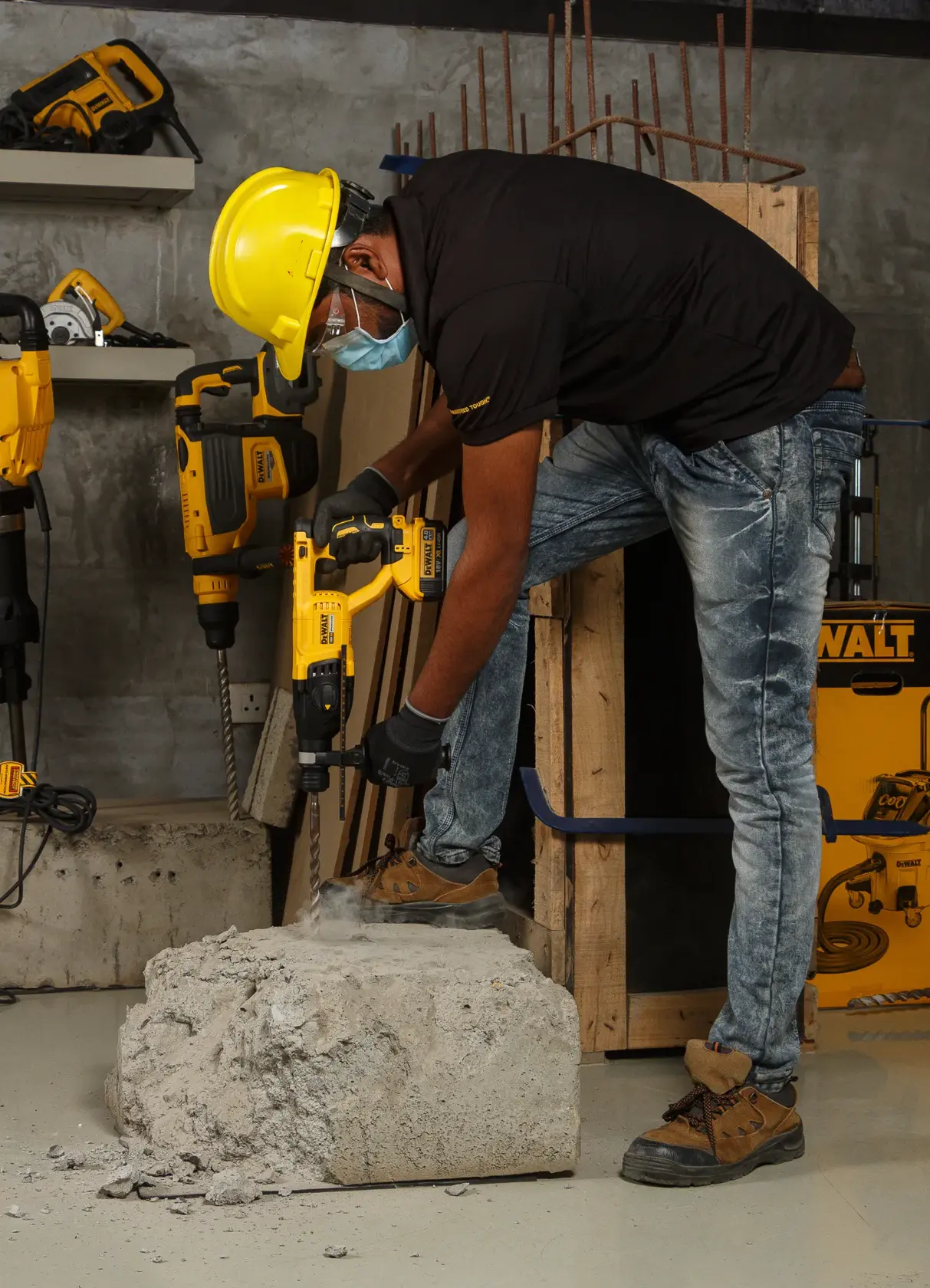 Trabajador usa DEWALT DCH133NT en concreto, con equipo de seguridad en obra de construcción.