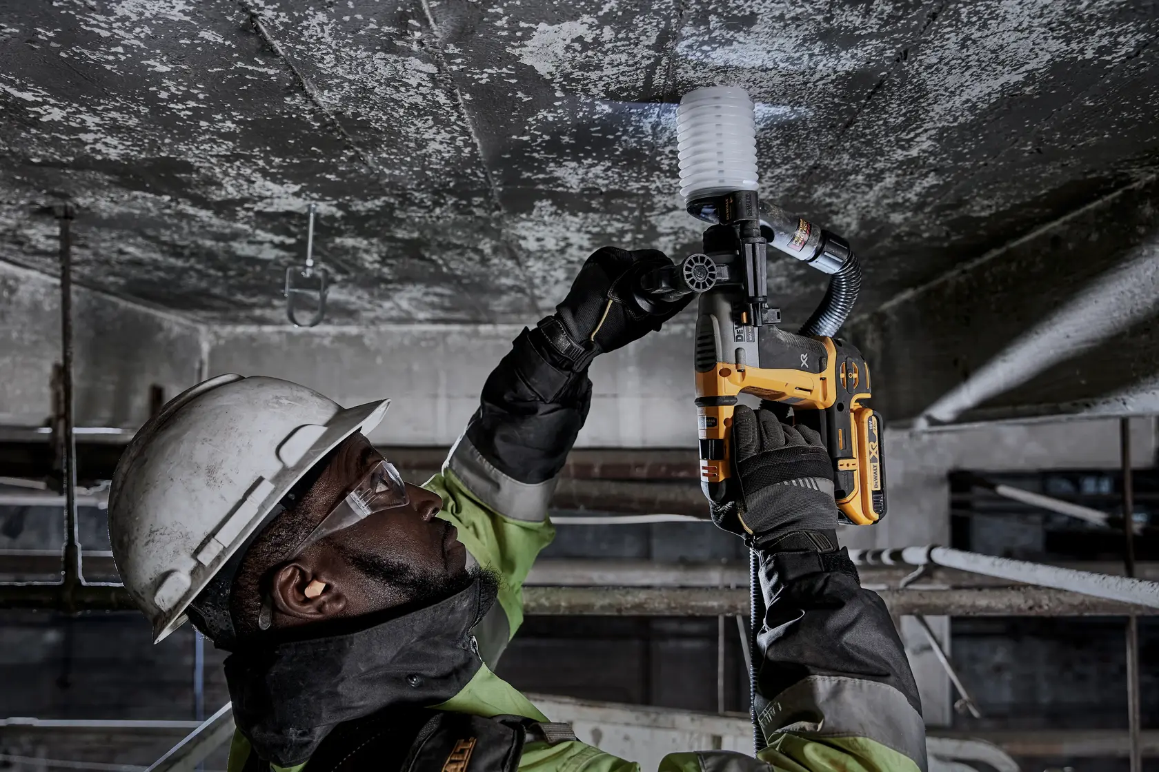 Trabajador taladra techo con DEWALT DCH172NT-XJ, DCH172NT martillo rotativo. Foto enfocada en el uso.