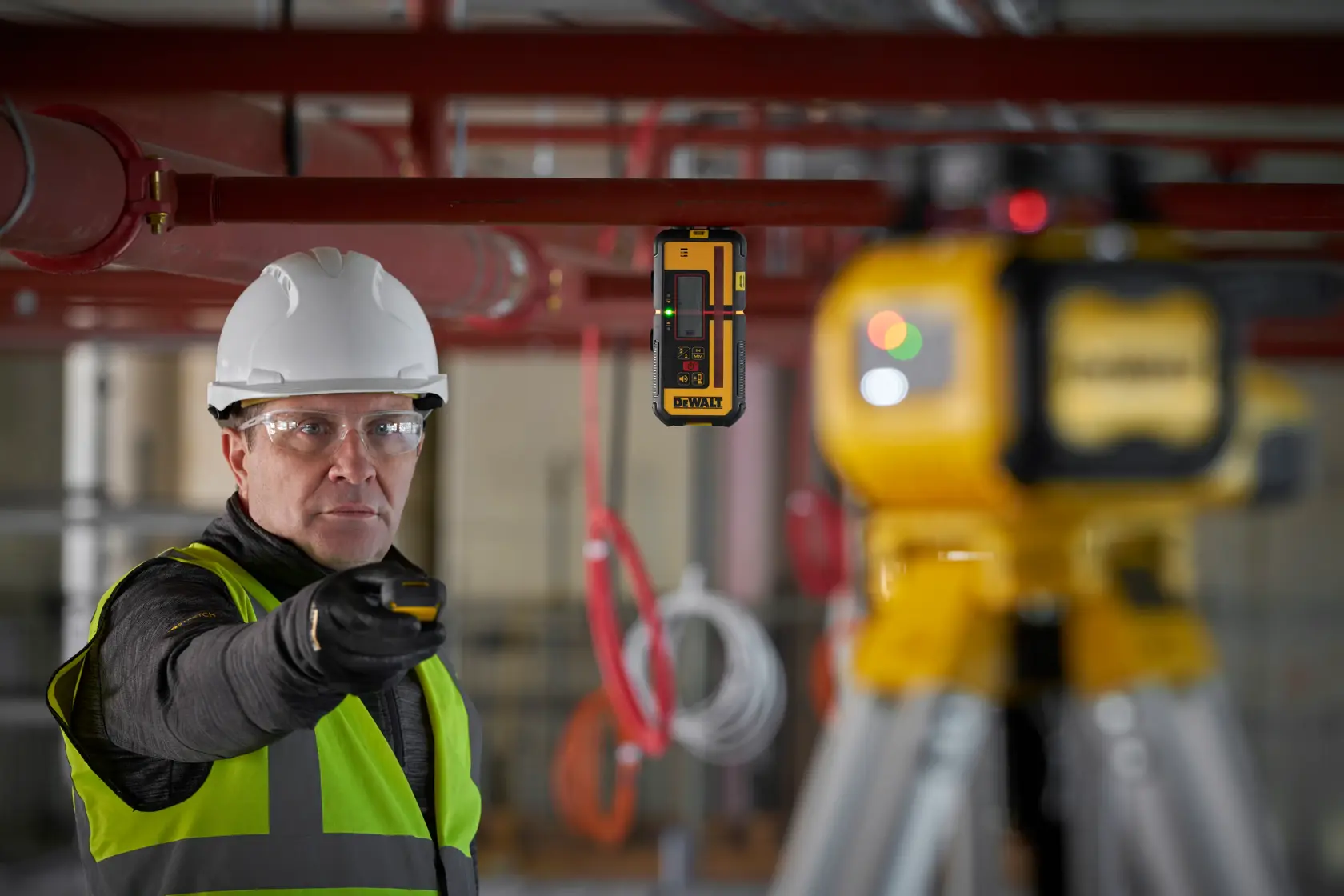 Trabajador usa DEWALT DCLE15211R, DCLE15211R-QW detector láser en obra. Producto de fotografía.