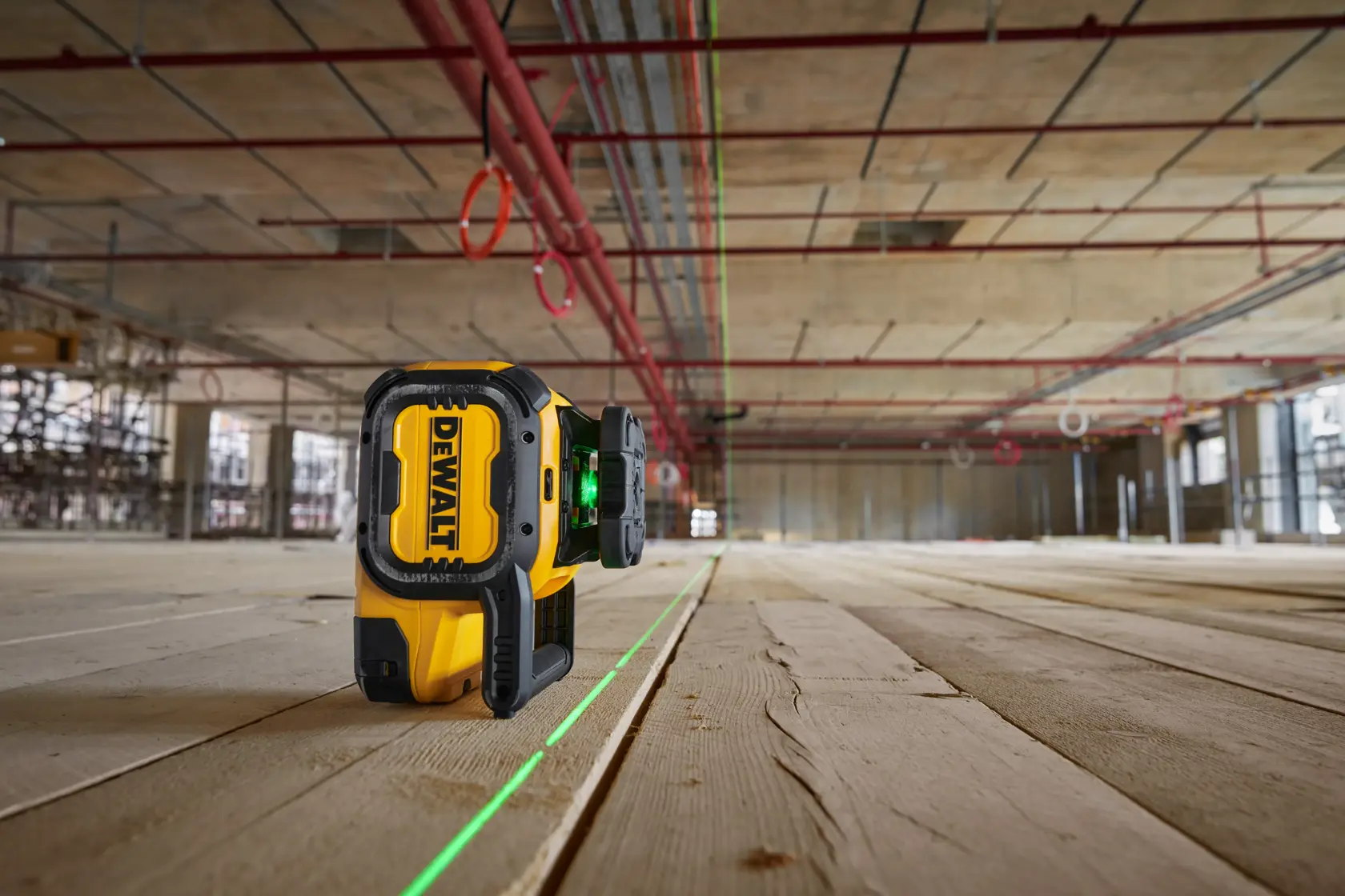 Herramienta láser verde fotografía DEWALT DCLE15221G-QW, DCLE15221G en piso madera obra.