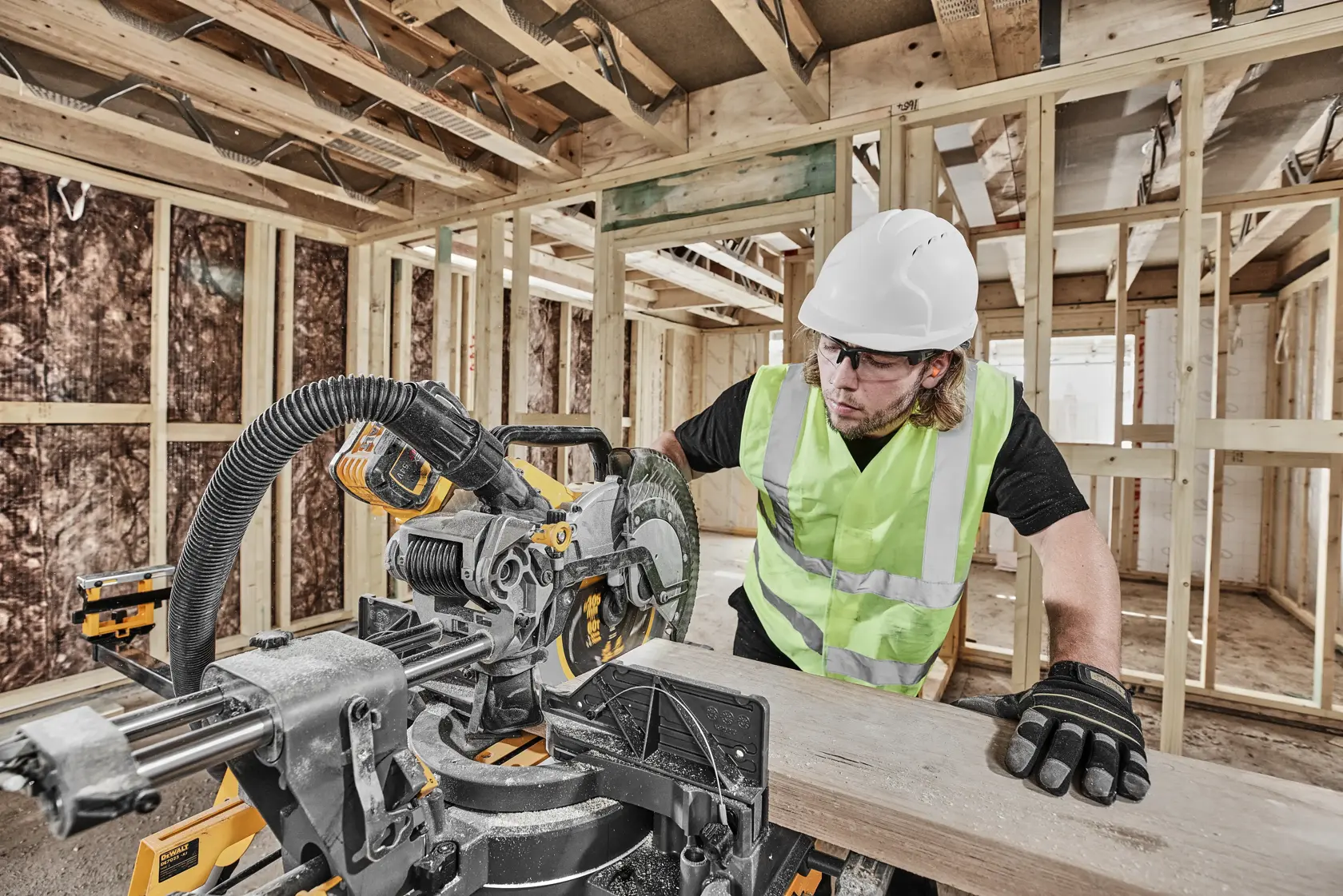 DEWALT DCS781X2-QW, DCS781X2 sierra en uso. Trabajador con equipo de seguridad cortando madera, fondo de obra.