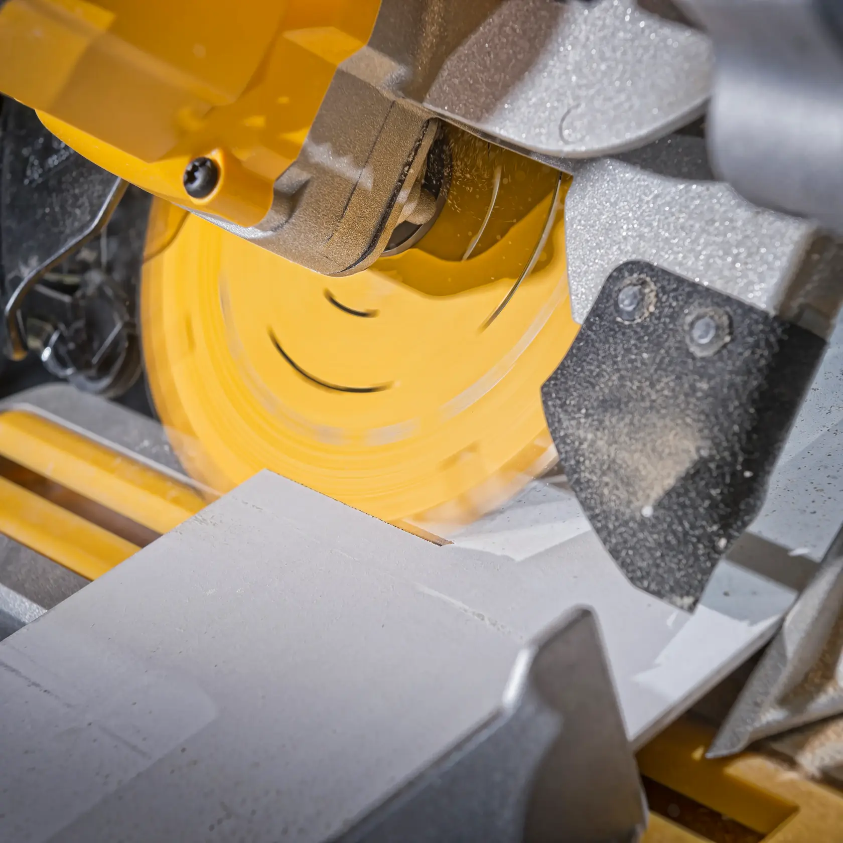 Primer plano de una sierra circular DEWALT cortando material. La hoja gira y genera polvo.
