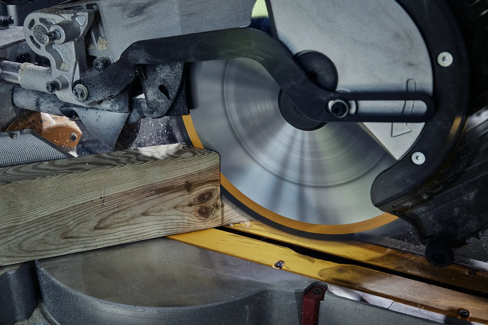 Primer plano de una sierra circular cortando una tabla de madera con precisión.