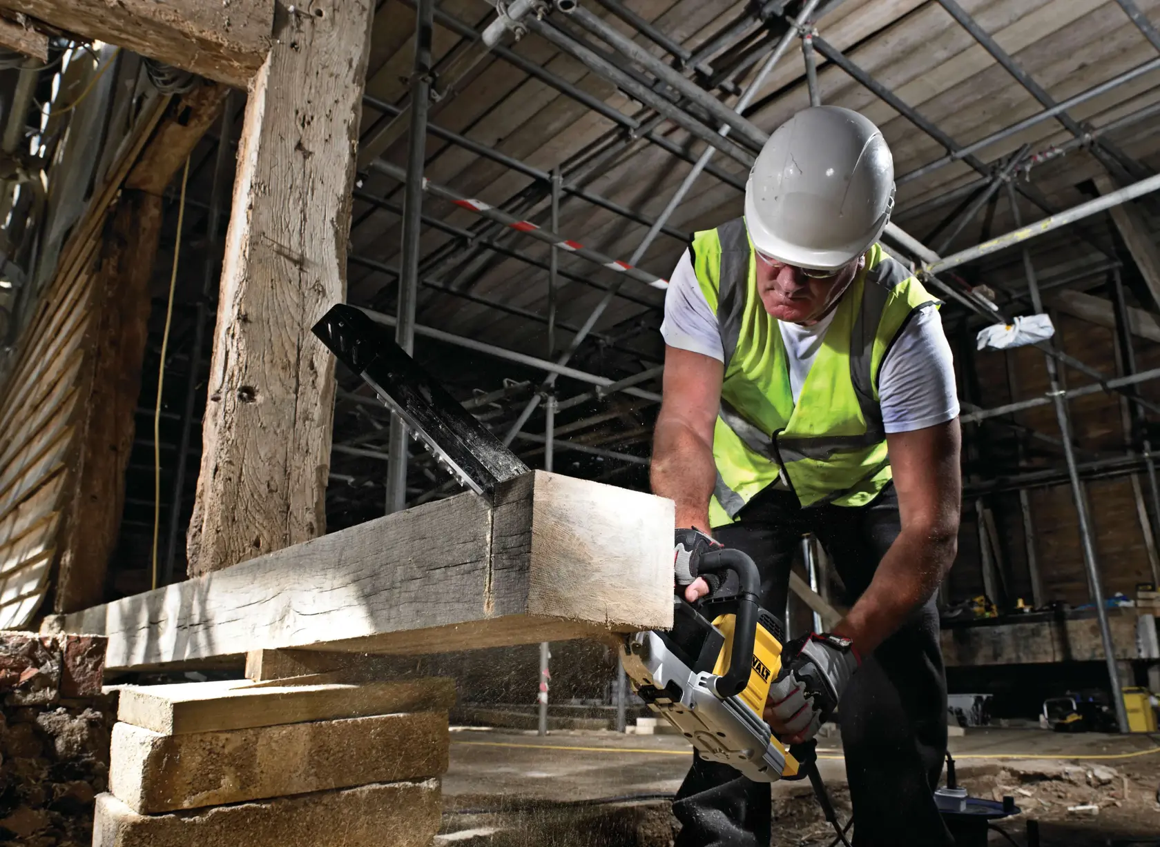 Trabajador corta viga de madera con sierra DEWALT en obra, con chaleco reflectante y casco.