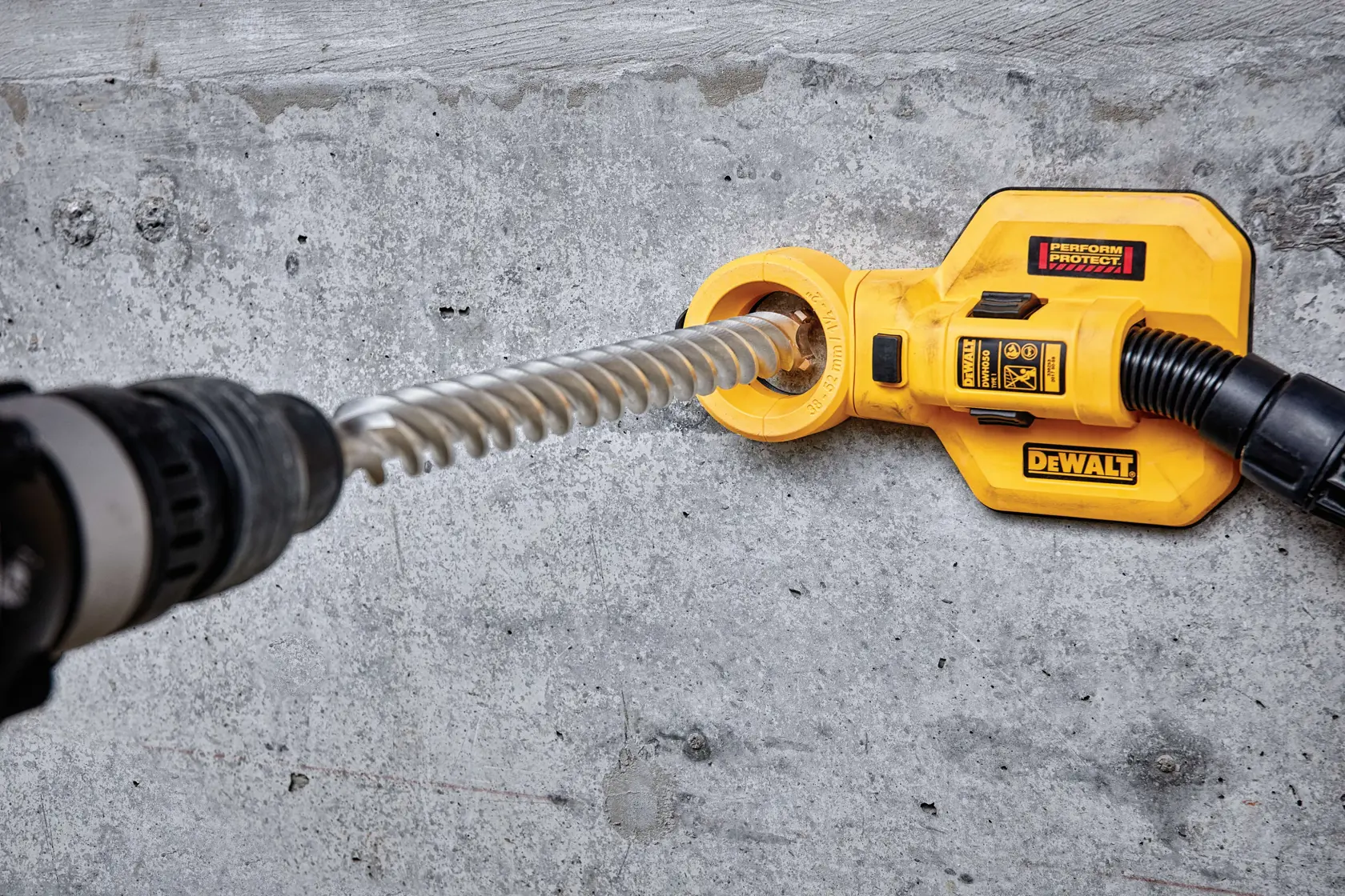 Accesorio DEWALT DT60842 en hormigón, conectado a herramienta rotativa para extracción de polvo.