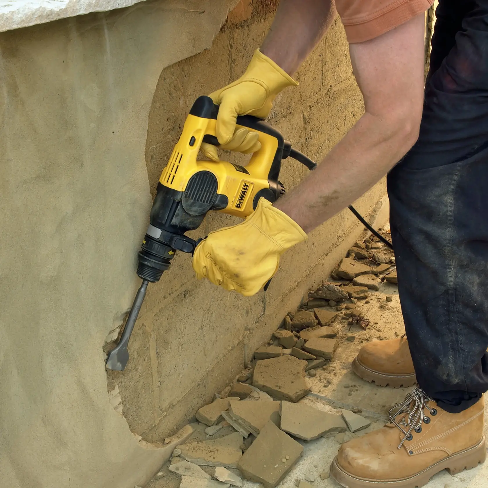 Trabajador retira azulejos azules de la pared usando una herramienta DEWALT.