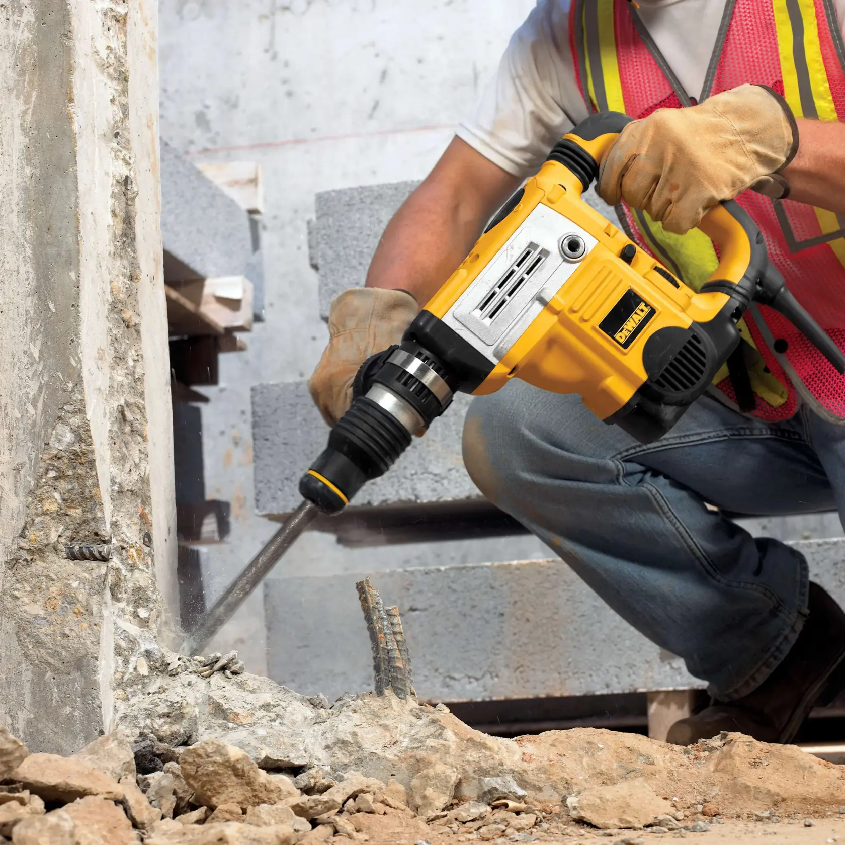 Rotomartillo DEWALT DT6824 rompe concreto en obra. El trabajador lleva guantes y chaleco de seguridad.