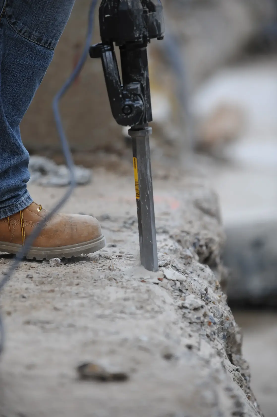 Foto de cincel DEWALT DT6927, DT6927-QZ en martillo demoledor rompiendo concreto.