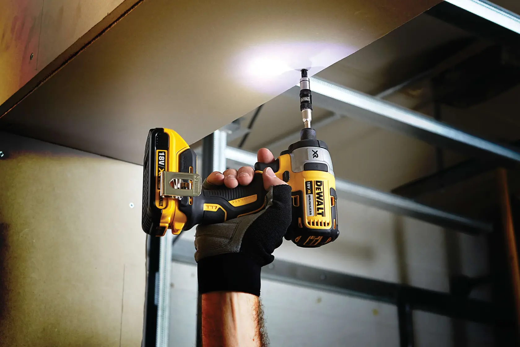 Foto de atornillador de impacto DEWALT DT70518T usado sobre la cabeza, guante, espacio interior.