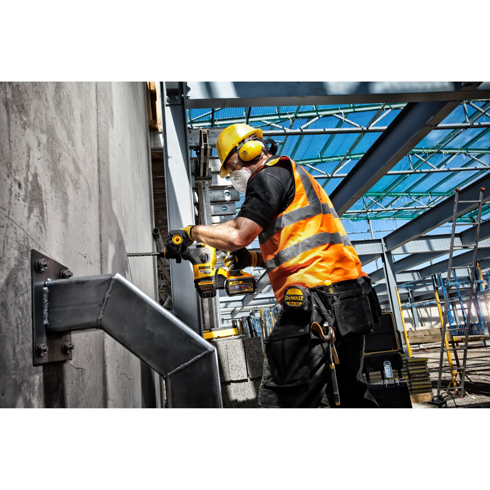 Trabajador perfora muro de concreto con herramienta DEWALT, equipado con protección en obra.