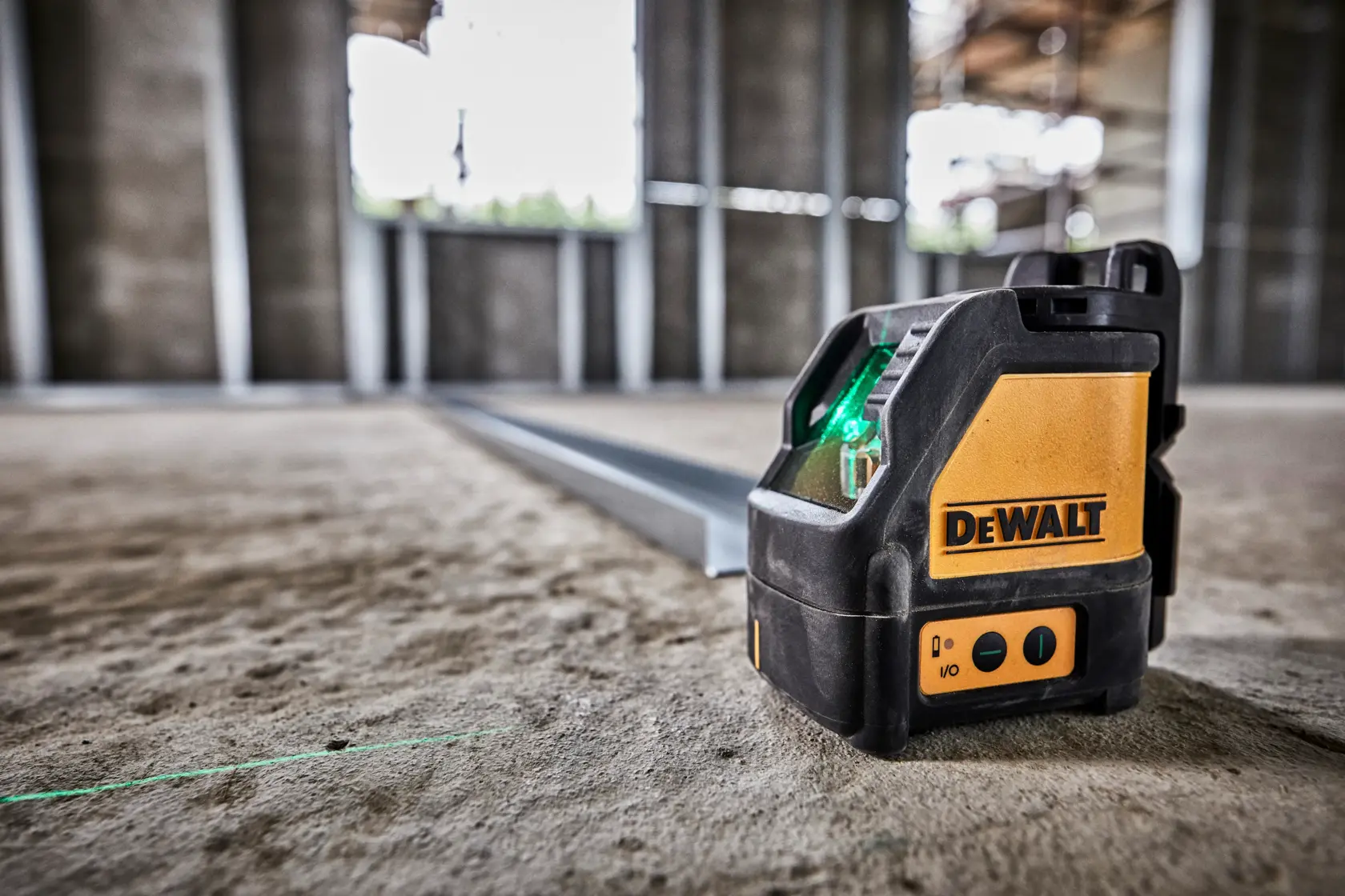 Un générateur de ligne laser DEWALT DW088CG noir et jaune, présenté avec des étiquettes d'avertissement et de conformité. L'appareil possède un boîtier noir robuste et deux bandes métalliques sur le côté.
