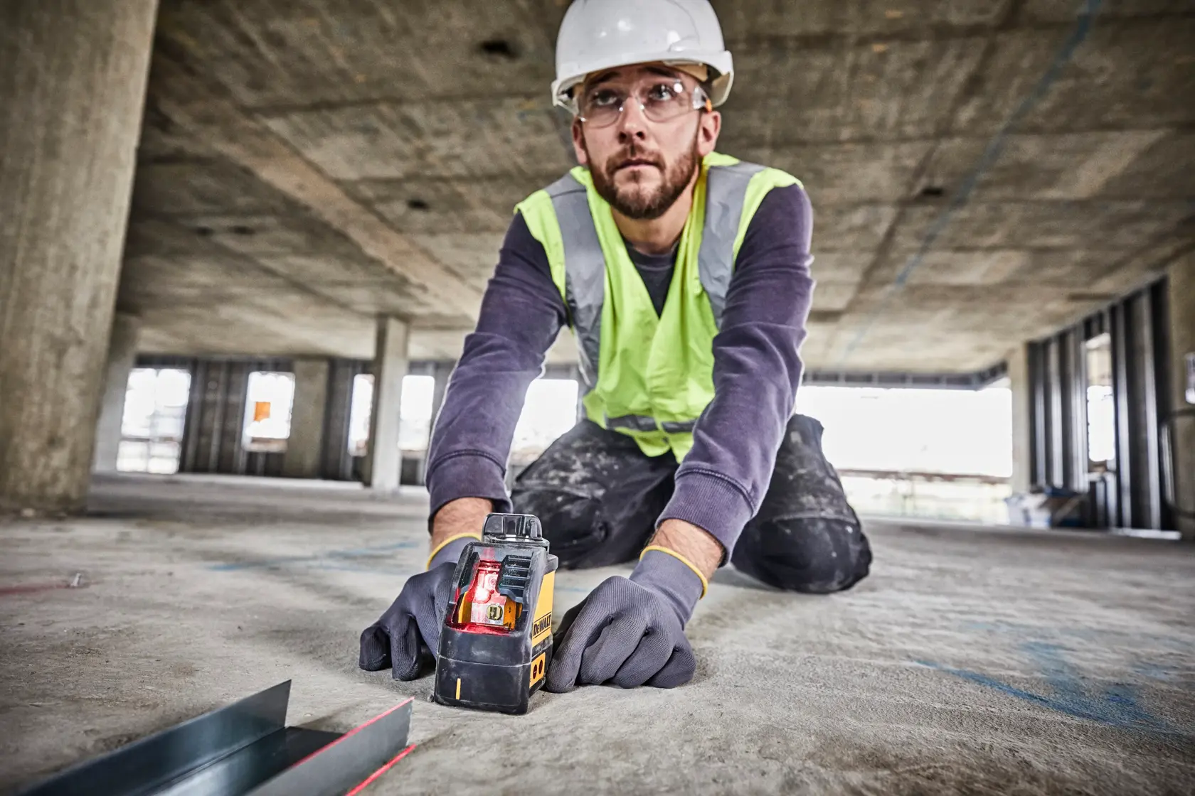 Dewalt DW088K cross line laser level. The device is yellow and black, features control buttons on the front, and has the Dewalt logo on the side. It is housed in a sturdy casing.