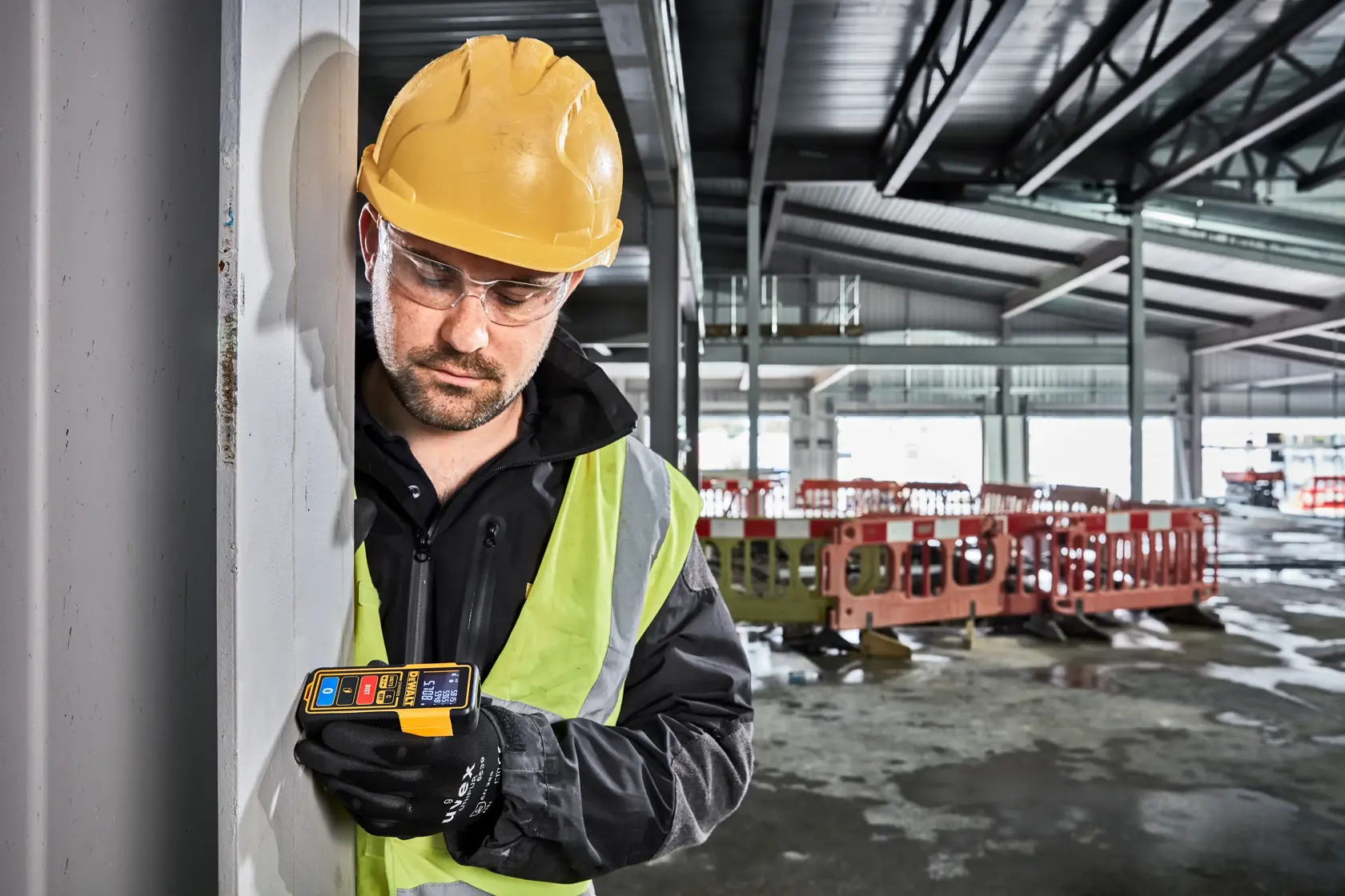 A DEWALT DW099S laser distance measurer with a yellow and black casing, digital screen displaying measurements, and multiple buttons including units, off, distance, and Bluetooth functions.