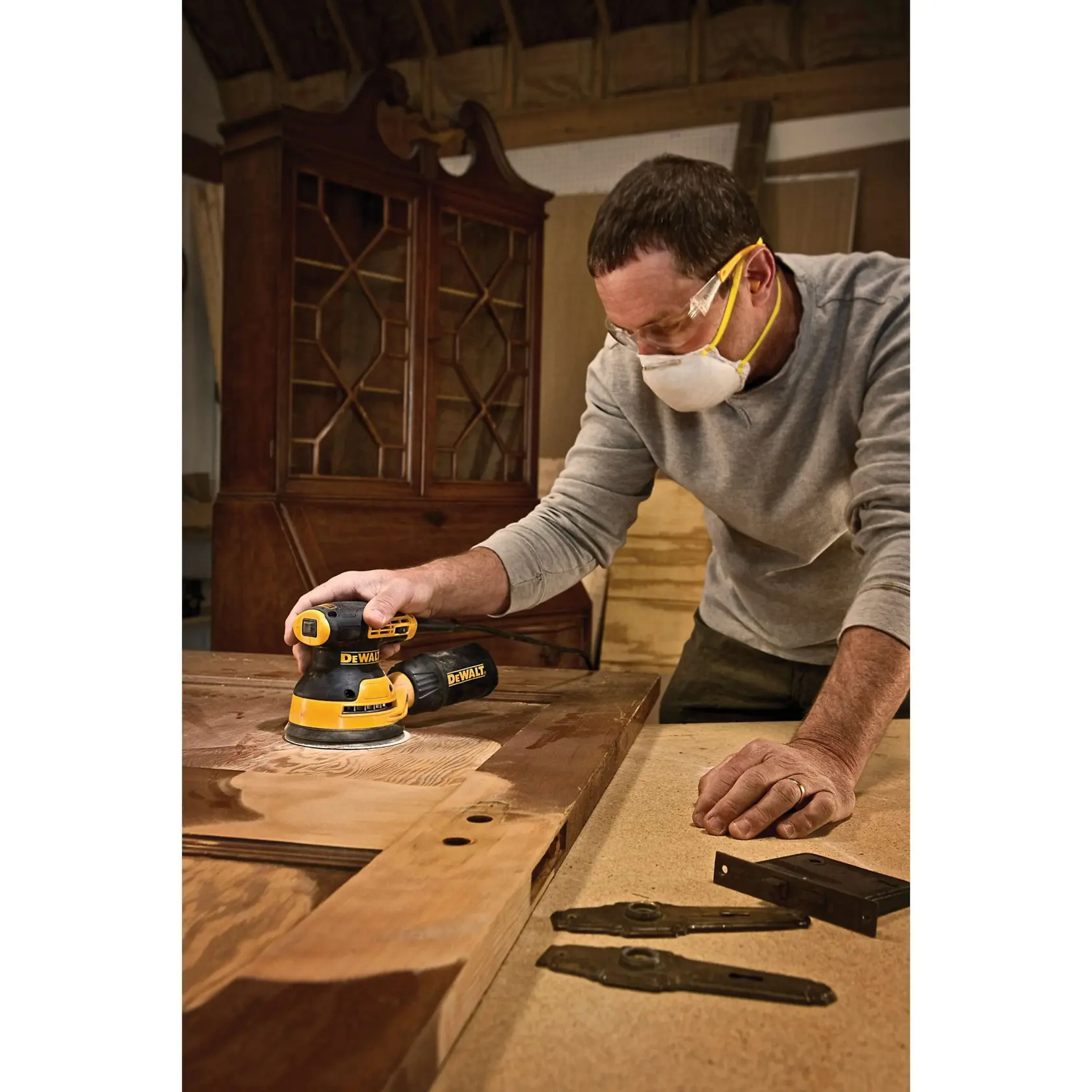 Une ponceuse orbitale aléatoire DEWALT avec un sac à poussière et une mallette de transport noire, tous arborant le logo DEWALT.