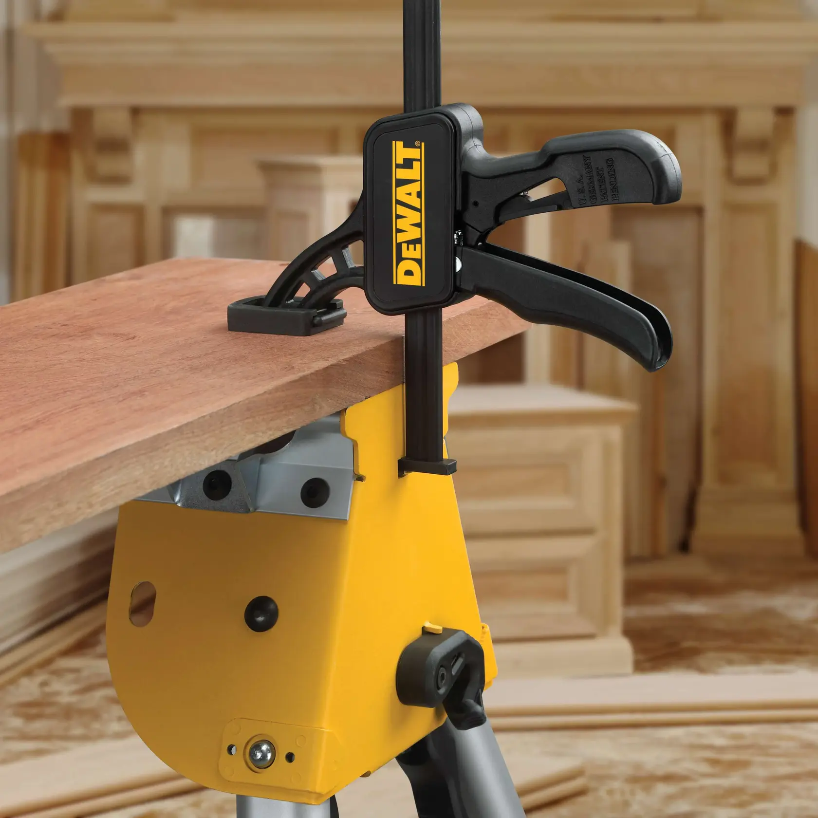 Foto de DEWALT DWS5026 sujetando madera en caballete amarillo. Fondo taller. SKU: DWS5026.